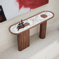 Elegant wood console table featuring a white marble top with dark veining and circular accents. Modern design elements.
