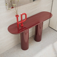 Sleek maroon console table with rounded edges and glossy finish, supported by two bold cylindrical bases.