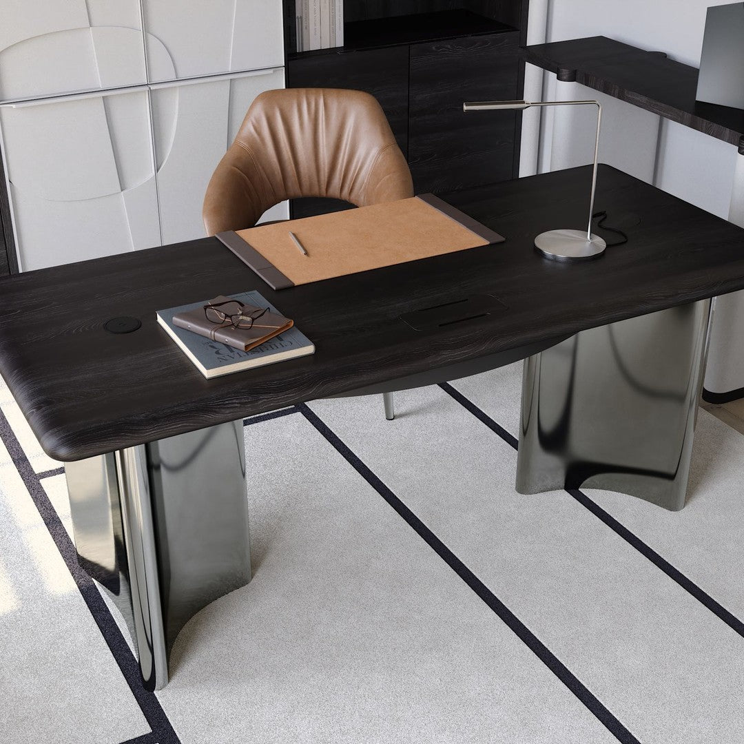 Elegant black desk with smooth wood grain, sleek metallic legs, and a warm brown leather chair against a light rug.