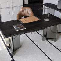 Elegant black desk with smooth wood grain, sleek metallic legs, and a warm brown leather chair against a light rug.