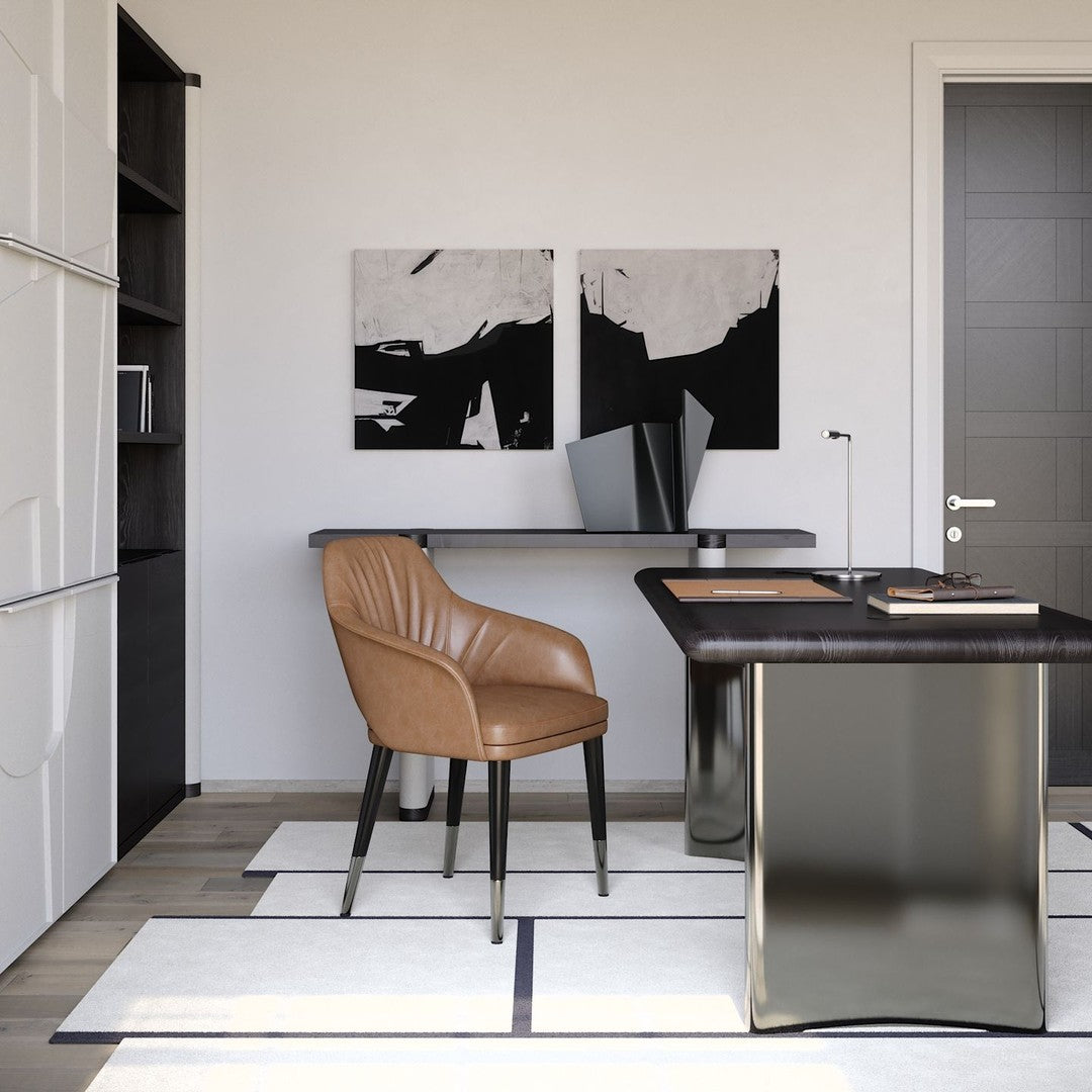 Brown leather chair on a minimal white and black patterned rug, with sleek silver desk and abstract wall art.