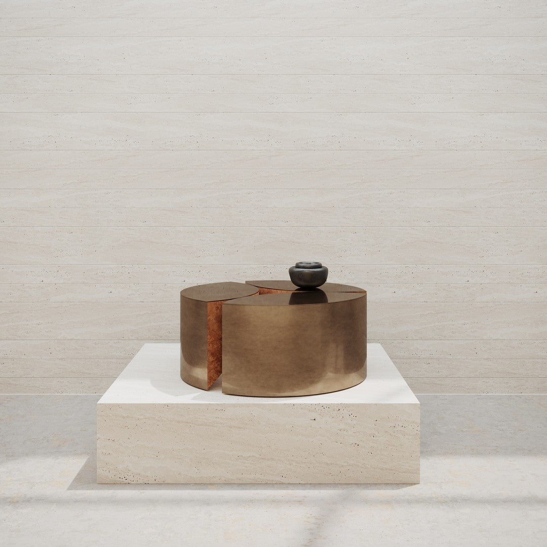"Bronze-toned decorative piece with a smooth, sleek finish on a light stone pedestal."