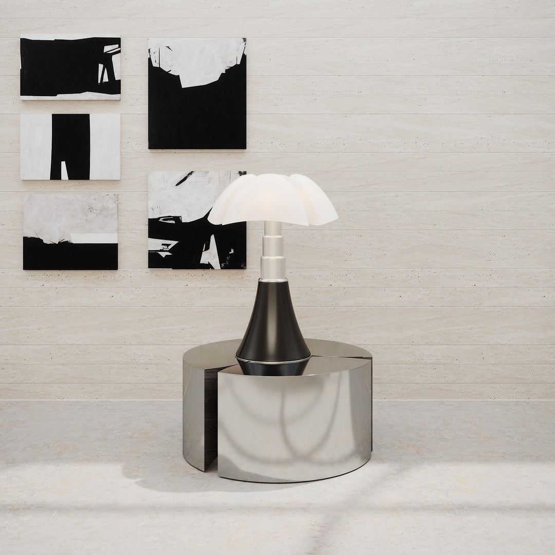Stylish black and white lamp on a sleek metallic table, set against abstract monochrome artworks.