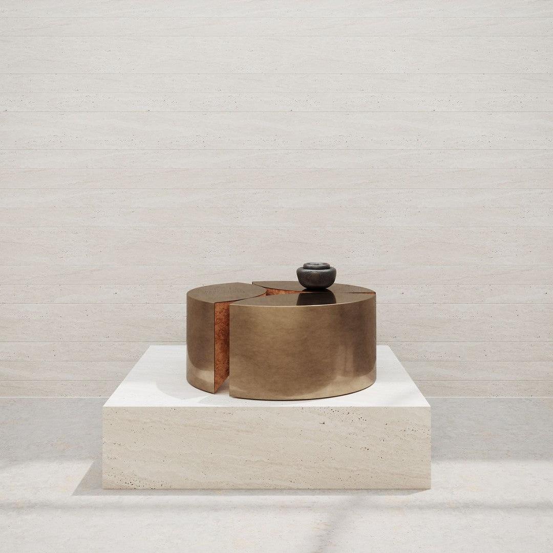 Brushed gold circular decor with black accent on a light stone base, showcasing modern minimalist design.