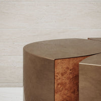 Sleek brown geometric coffee table with a warm burlwood accent against a light stone background.
