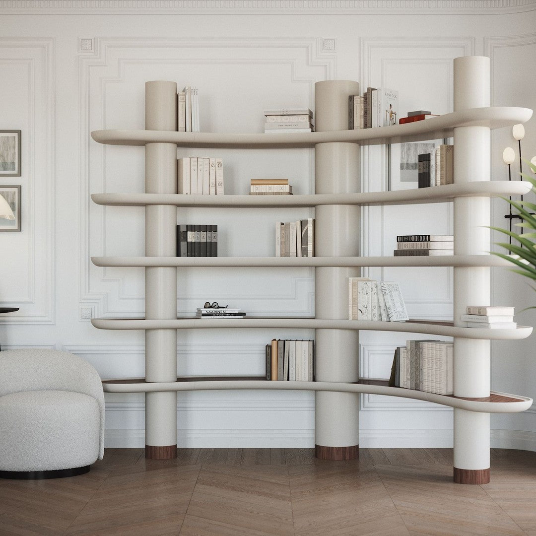 Elegant cream bookshelf with curved shelves and warm wood accents, set against a classic white wall.