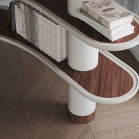 Curved shelves with a light wood finish and rich walnut accents, featuring cream-colored edges and elegant book arrangement.