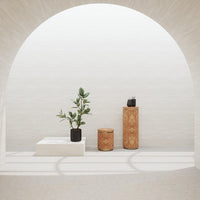 Modern decor scene featuring earthy tones, textured surfaces, and greenery against a minimalist background.