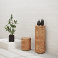 Cork accent table set in natural tones with smooth, textured surfaces and contrasting black vases. Modern, minimalist design.