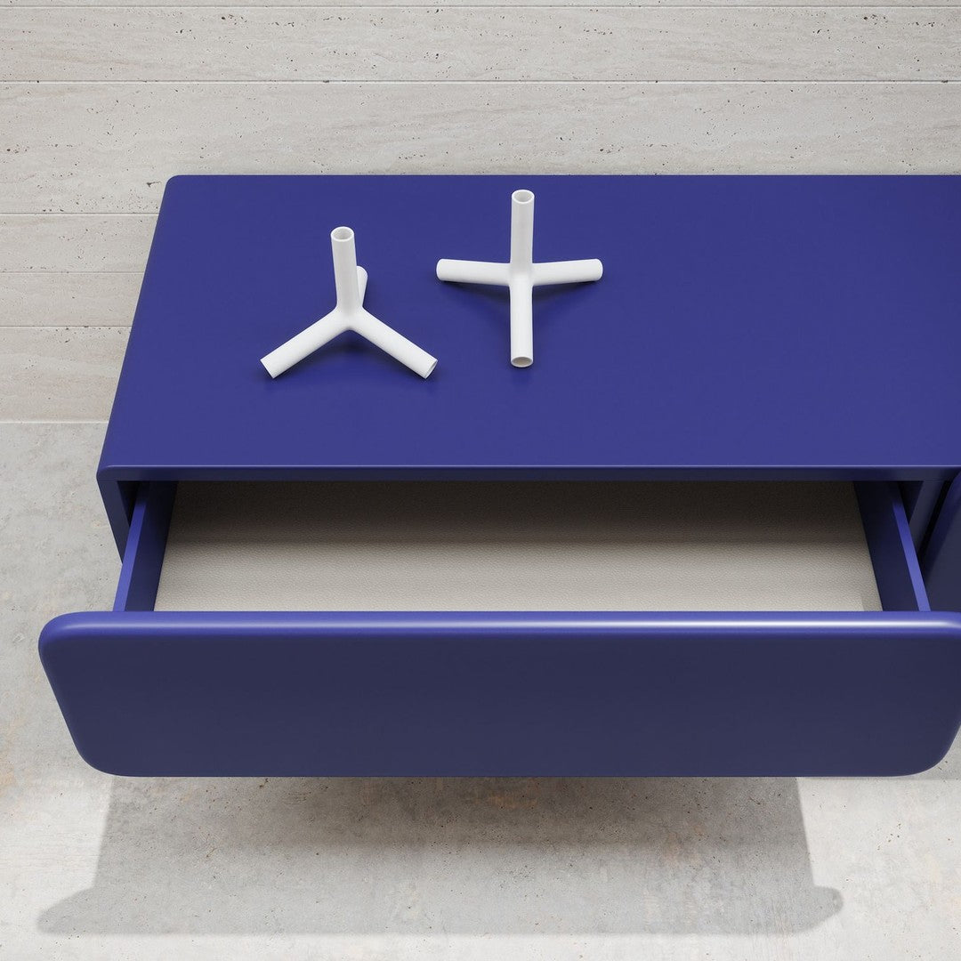 Vibrant purple drawer with clean lines, complemented by white geometric drawer pulls. Modern design elements.