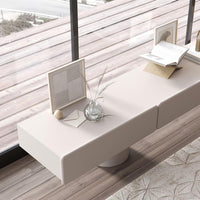 Minimalist cream coffee table with smooth surface, featured on warm-toned wooden flooring and geometric-patterned rug.