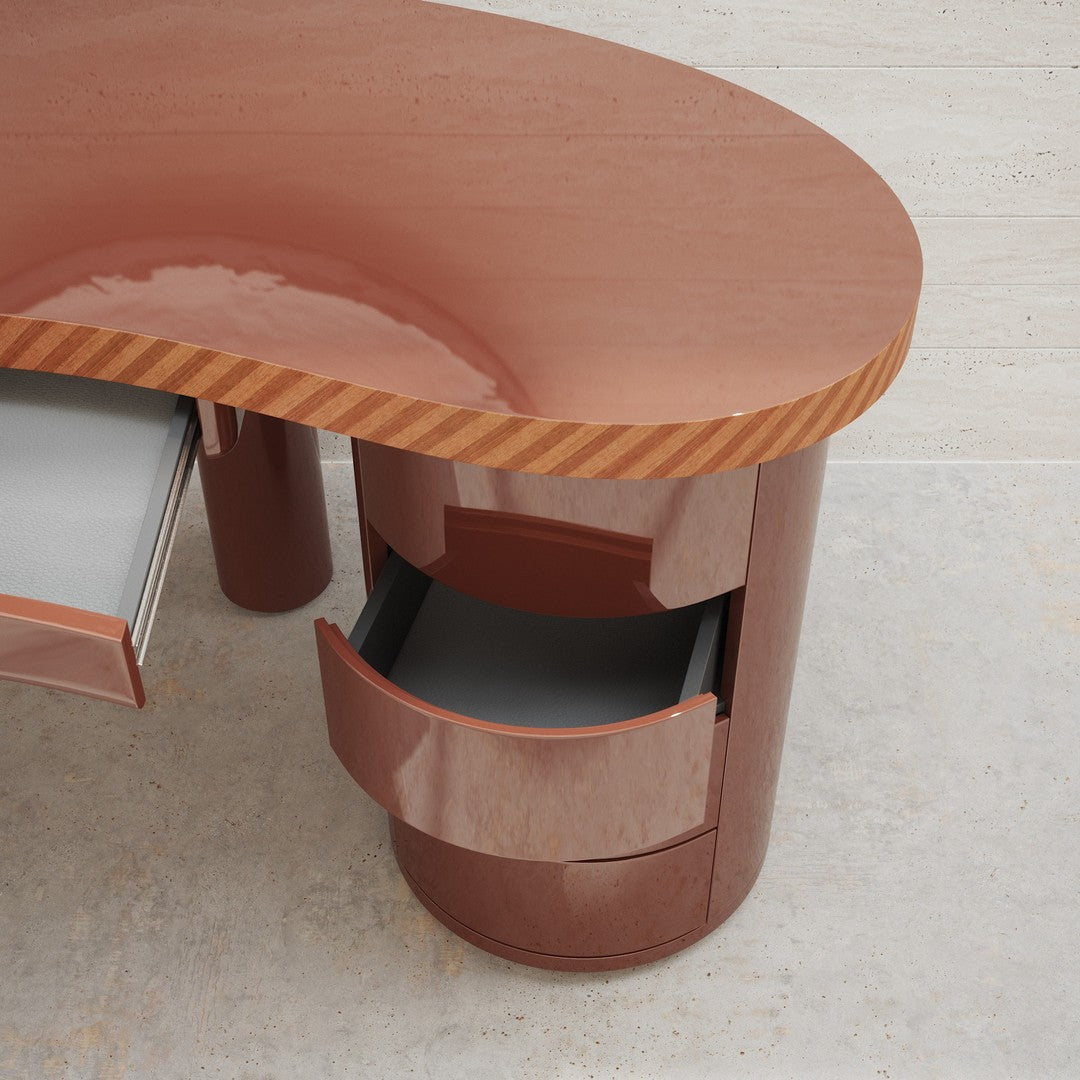 Curved brown desk with glossy finish and striped pattern on the edge, featuring two open drawers.