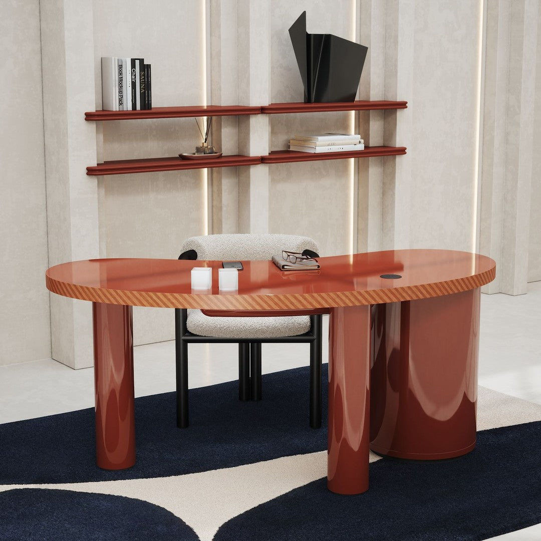 Glossy red oval desk with striped top and rounded legs, paired with a neutral chair on a dark blue patterned rug.