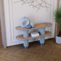 Light blue two-tier shelf with natural wood pattern, complemented by decorative vases and a minimalist white box.