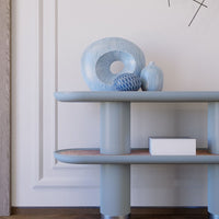 Blue ceramics on a light blue shelf, featuring textured patterns and subtle earthy accents.