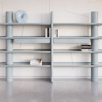 Light blue modern shelving unit with smooth, rounded edges and minimalist design, featuring open shelves and subtle patterns.