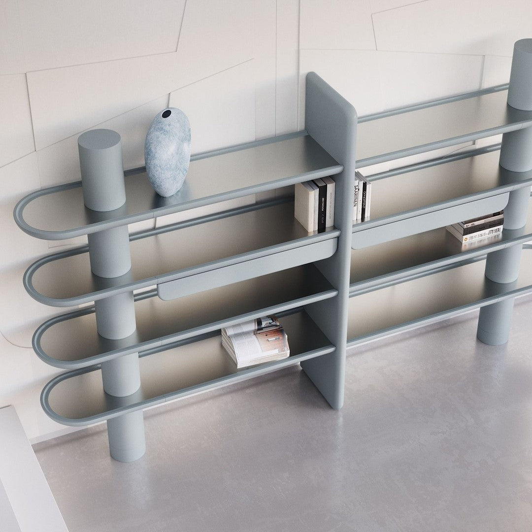 Modern light blue bookshelf with sleek curved lines and minimalist design, featuring a smooth finish and geometric patterns.