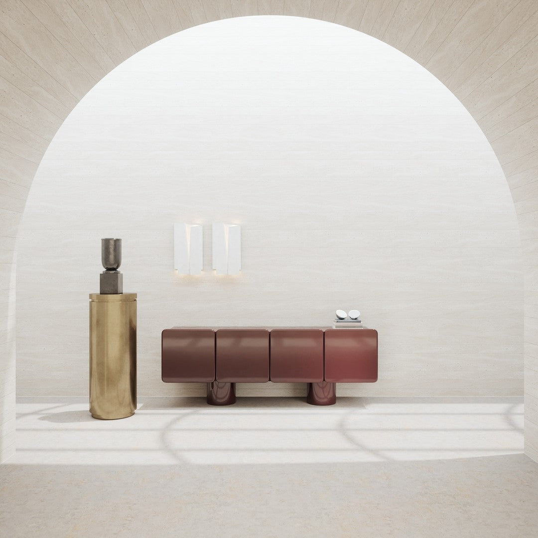 "Modern interior featuring a shiny gold sculpture and deep burgundy storage console against a light textured backdrop."