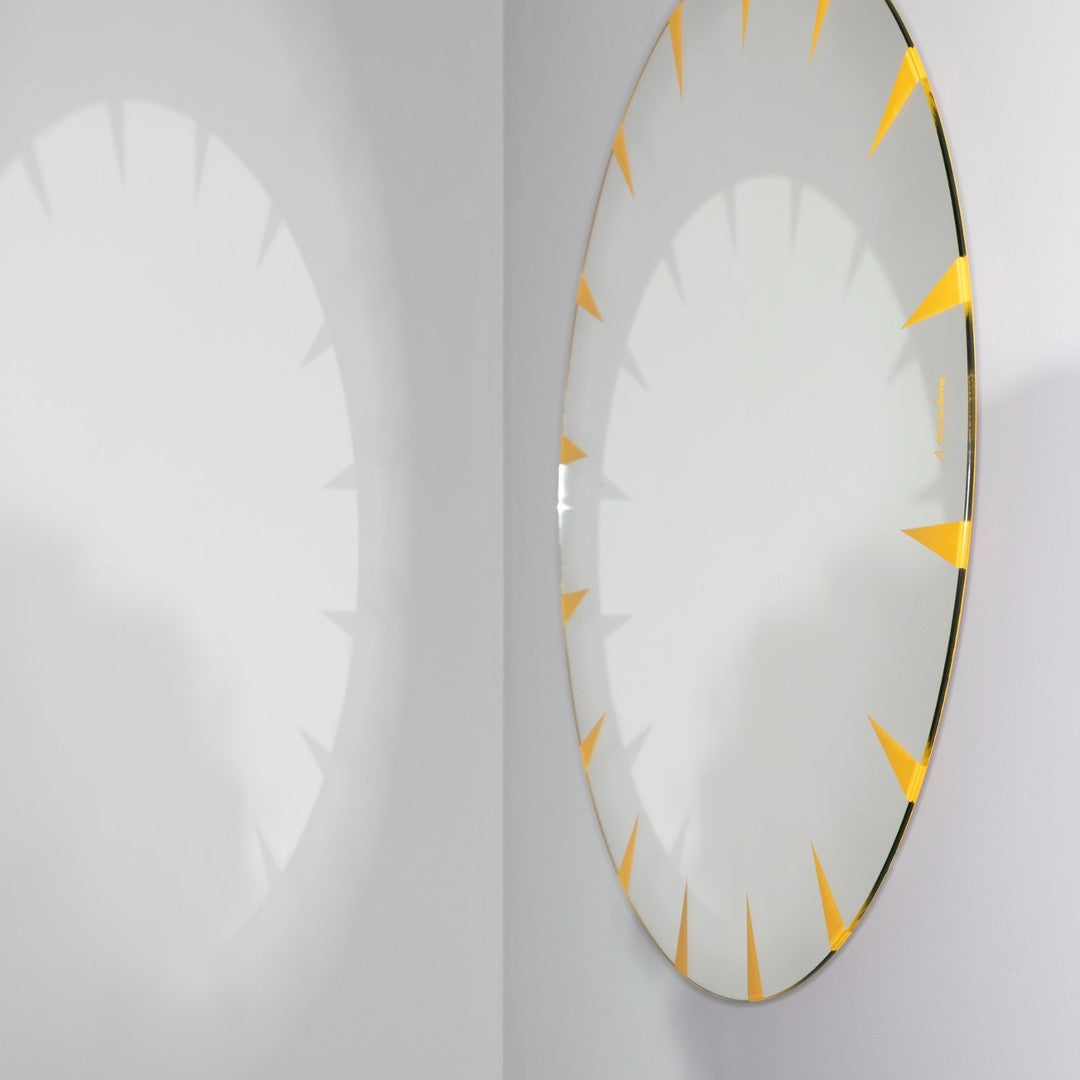 Round mirror with a clear surface and vibrant yellow sunburst pattern along the edge, enhancing modern decor.