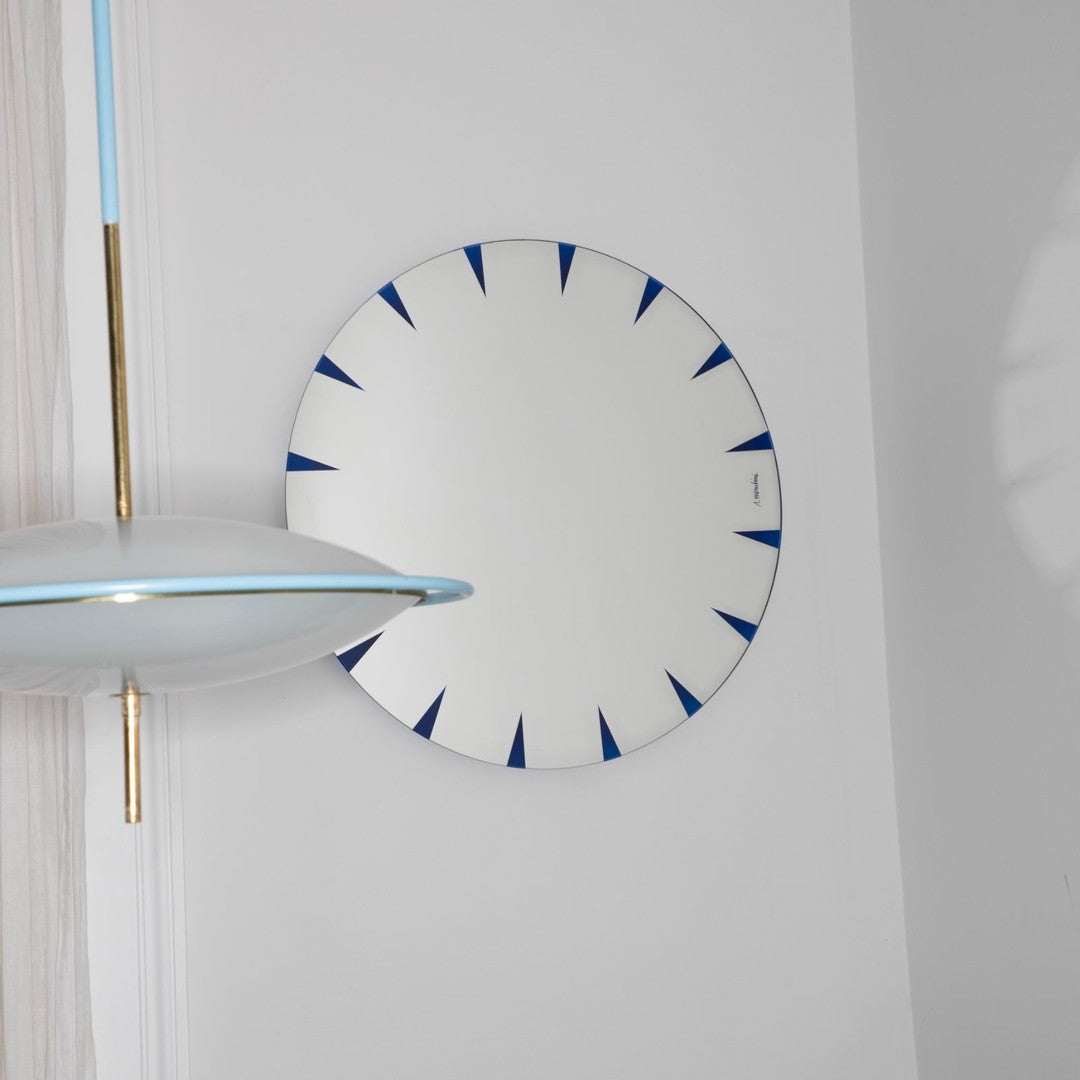 White circular mirror with blue accents and geometric spike pattern, ideal for modern decor.