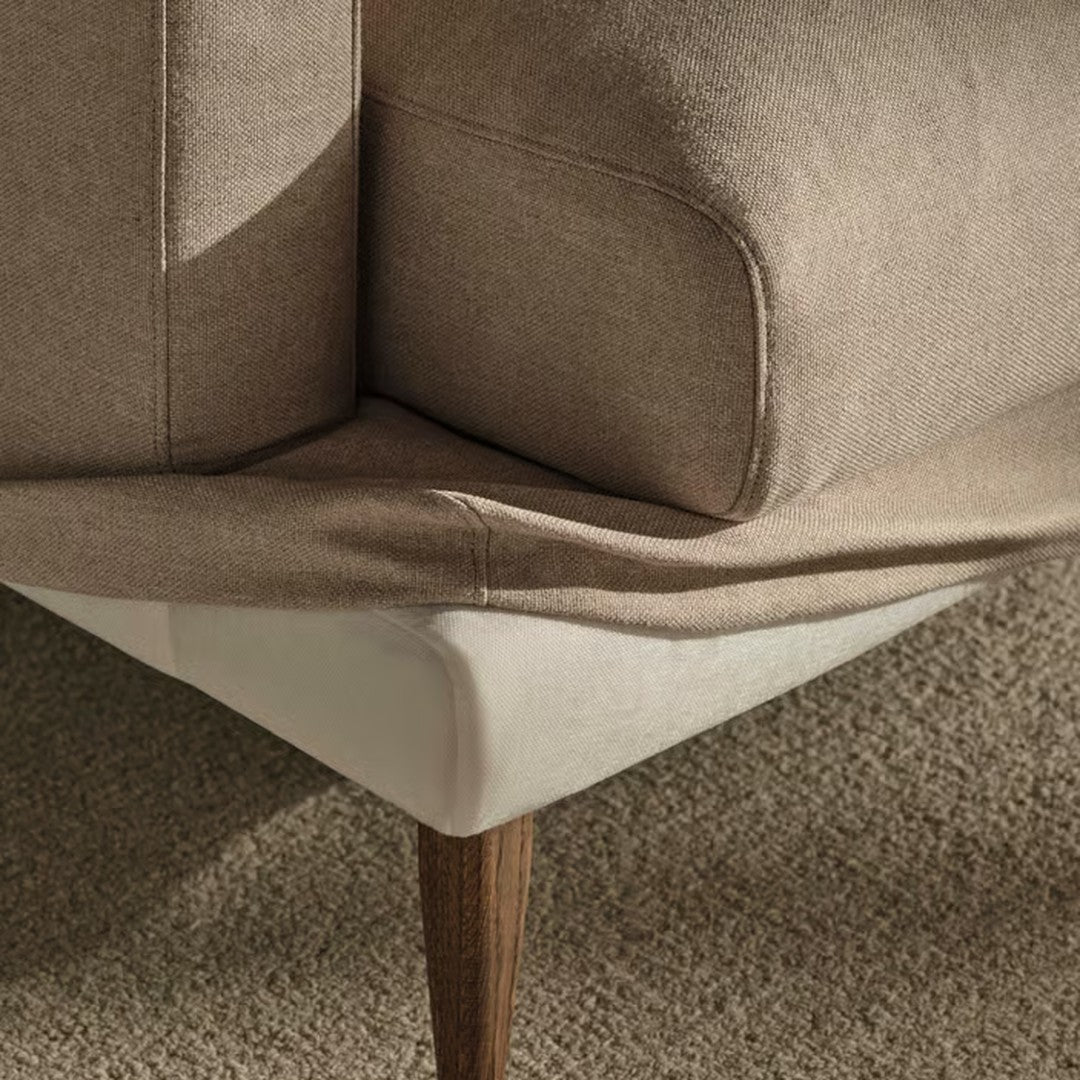Beige fabric with textured pattern and cream detailing. Features wooden legs for a modern look.