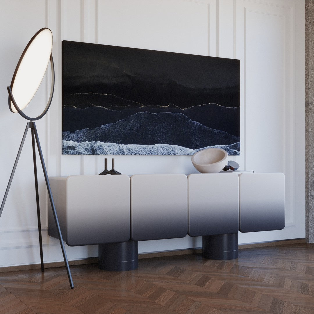 Modern gray ombre cabinet with a black and white abstract painting, set against a light wall and wooden floor.