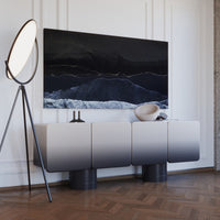 Modern gray ombre cabinet with a black and white abstract painting, set against a light wall and wooden floor.