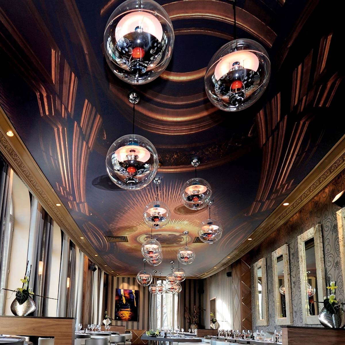 Elegant ceiling design with dark wood patterns, gold accents, and modern glass pendant lights. Sophisticated ambiance.