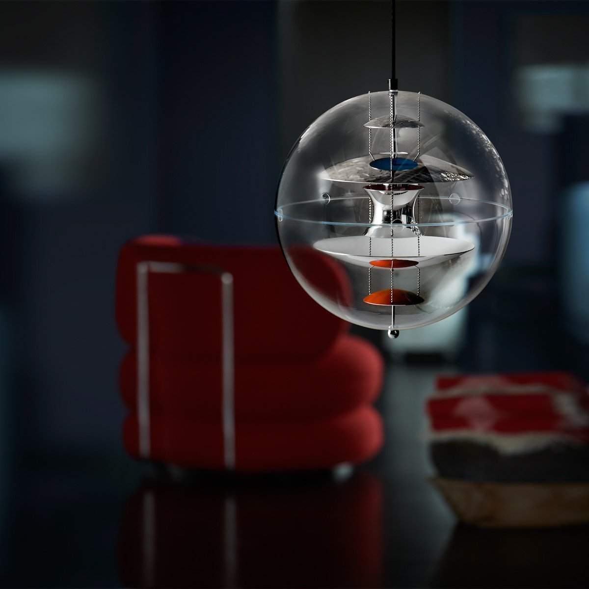Clear glass pendant light with intricate patterns, featuring vibrant orange and blue accents against a dark backdrop.