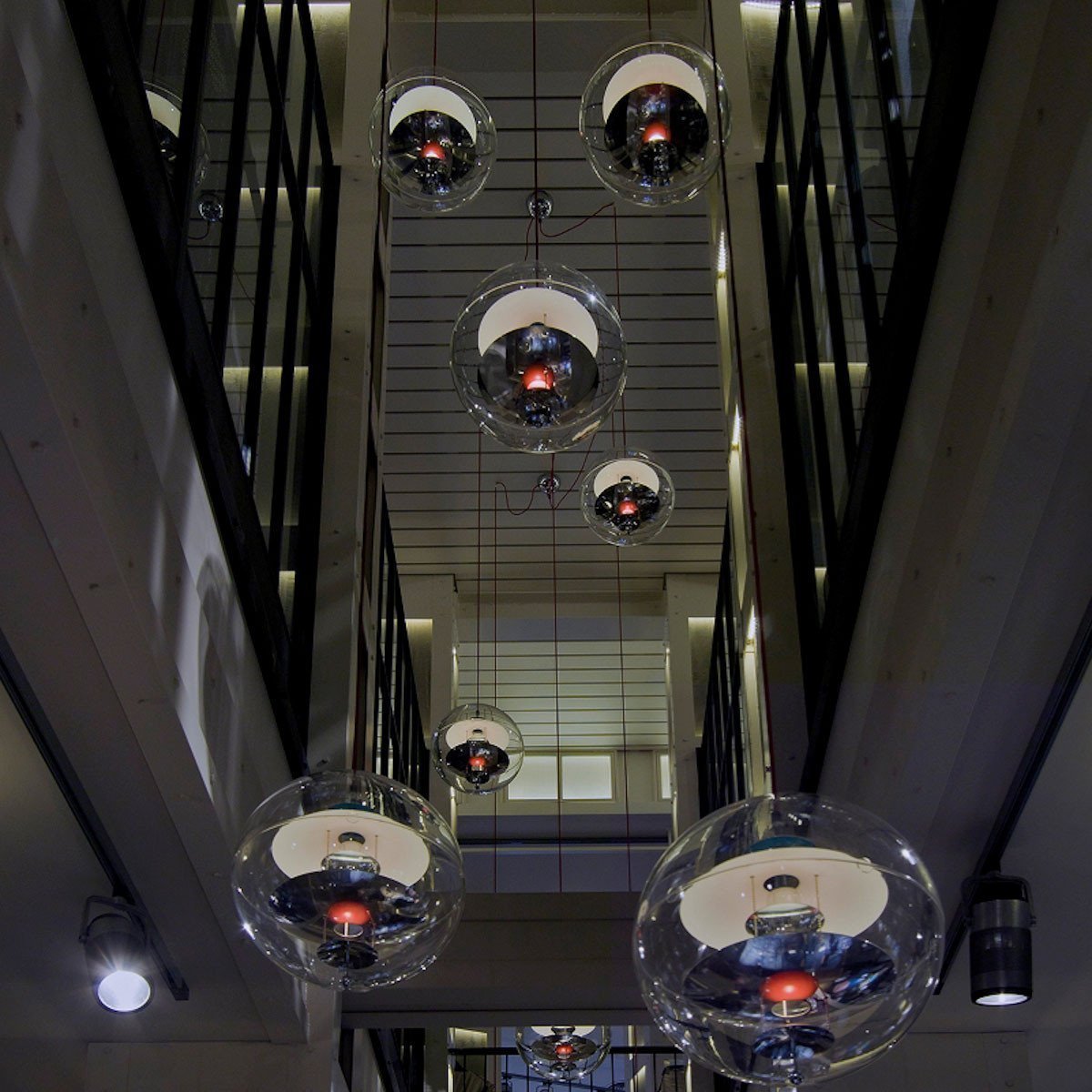 "Modern glass pendant lights with reflective spheres and black and white accents, enhancing contemporary decor."