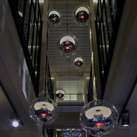 "Modern glass pendant lights with reflective spheres and black and white accents, enhancing contemporary decor."