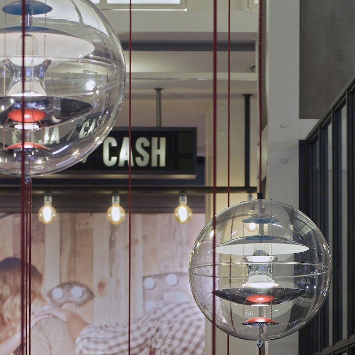 “Modern glass pendant lights with a clear outer layer and bold red accents, showcasing a sleek, contemporary design.”