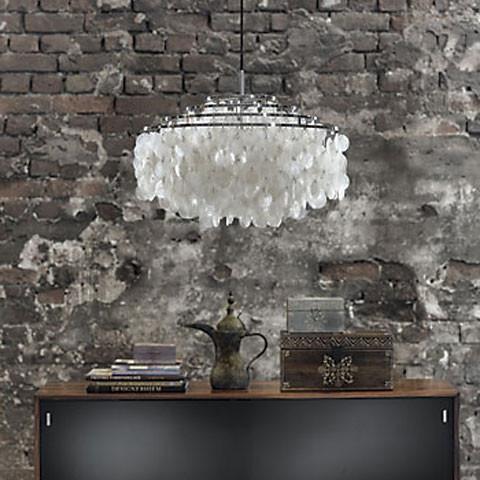 Elegant white chandelier with a textured pattern, set against a rustic gray brick wall. Ideal for modern decor.