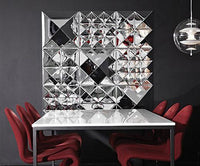 Modern silver wall display with geometric patterns, contrasting with a black background and deep red chairs.