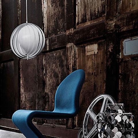 Modern blue chair with a white pendant light against a textured brown wall, showcasing sleek shapes and tones.