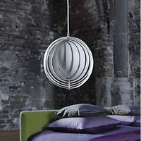 Modern white pendant lamp with layered circular design above a textured purple and green bedding set.