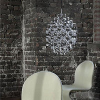 "Shimmering silver chandelier against textured dark brick wall; sleek white chair with subtle curves."