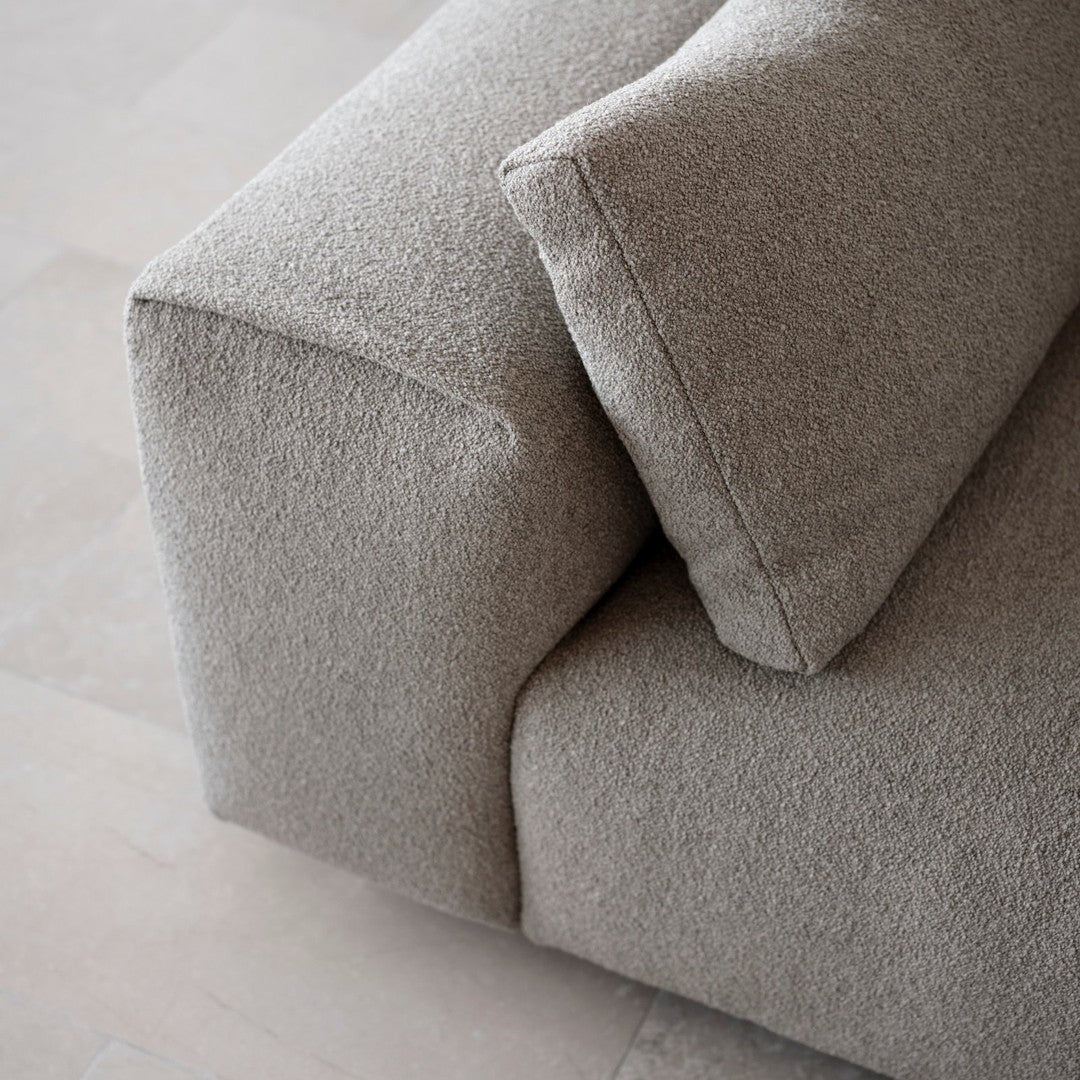 Textured light gray sofa fabric with plush cushions, showcasing a minimalist and modern design.