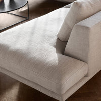 Light beige upholstered sofa with subtle texture, featuring clean lines and a modern design.