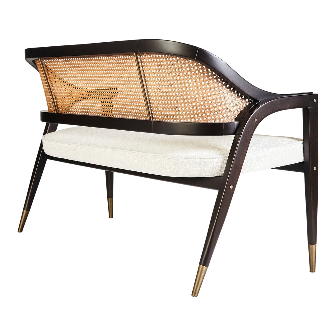 Mid-century modern sofa with a dark wood frame, woven cane back, and cream upholstered seat, featuring elegant gold accents.
