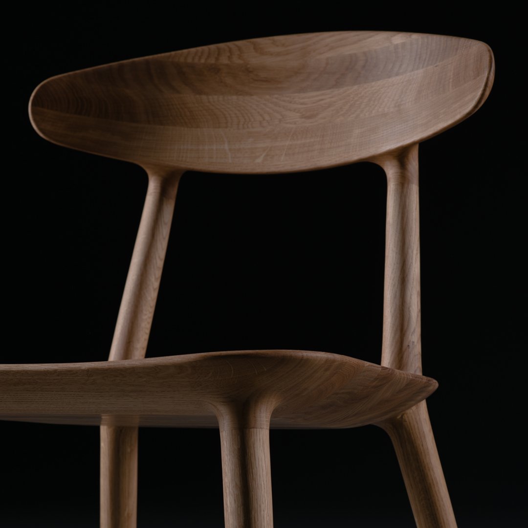 Elegant wooden chair in warm brown tones with smooth, curved lines against a black background.