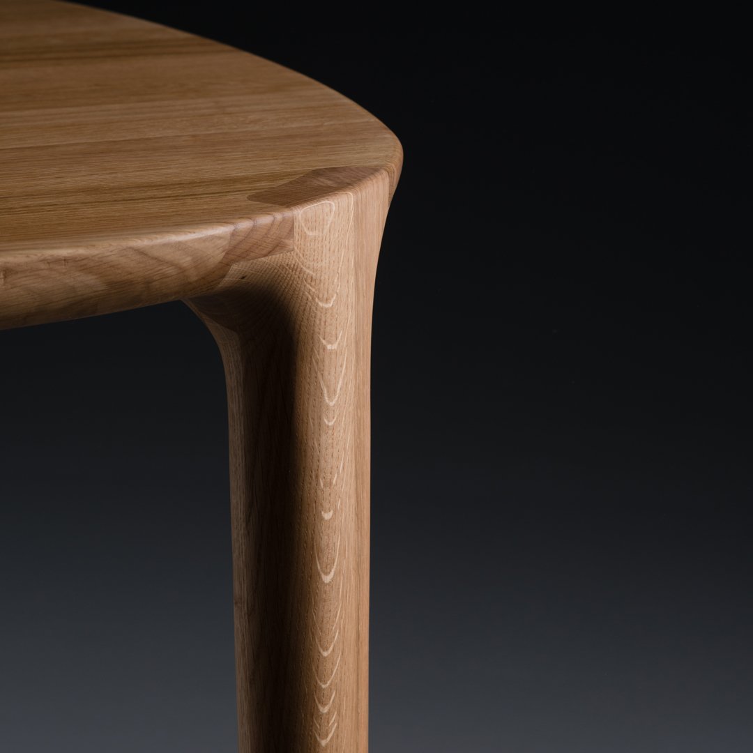 Light oak wood table with a smooth finish and subtle grain pattern, showcasing warm beige tones against a black background.