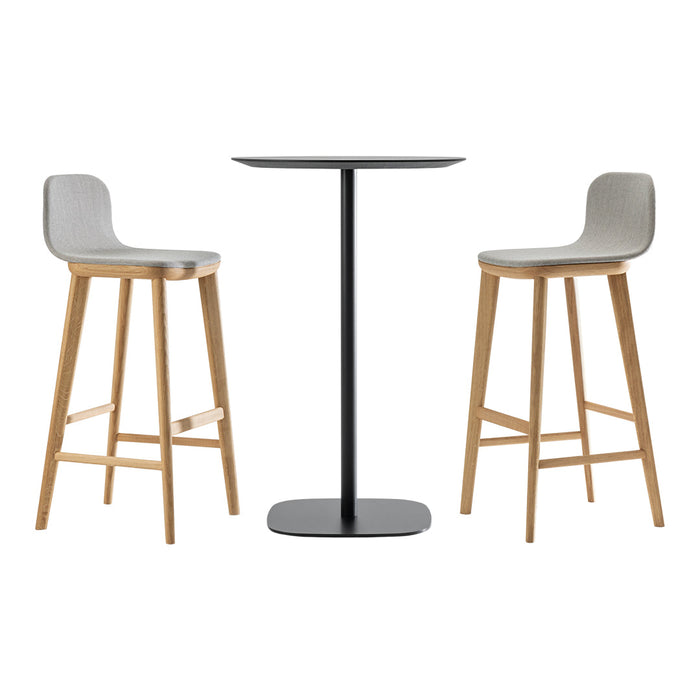 Gray bar stools with oak legs and a sleek black table feature minimalist design and contemporary colors.
