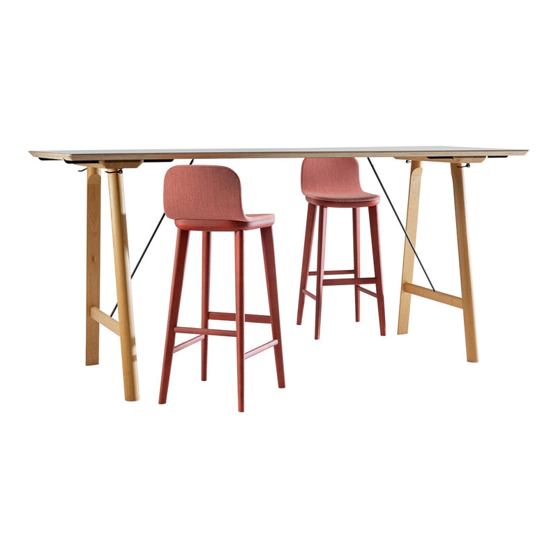 Light wood table with a sleek, smooth surface and two pink bar stools featuring subtle patterns.