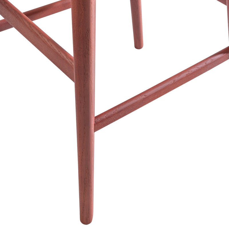 "Close-up of a wooden chair leg showcasing a rich reddish-brown finish with a smooth texture."