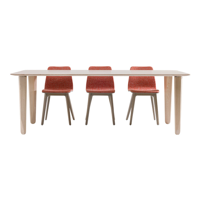 "Wooden dining table with a light finish and four red patterned chairs, creating a stylish modern look."
