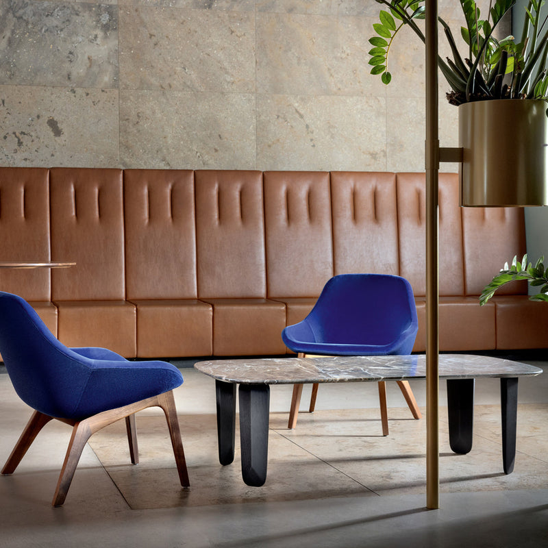 Blue chairs with wooden legs, brown leather backdrop, and a marble-patterned coffee table, creating a modern aesthetic.
