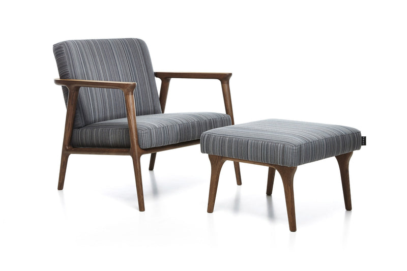 Gray striped fabric armchair and ottoman with wooden legs, combining modern and classic design elements.